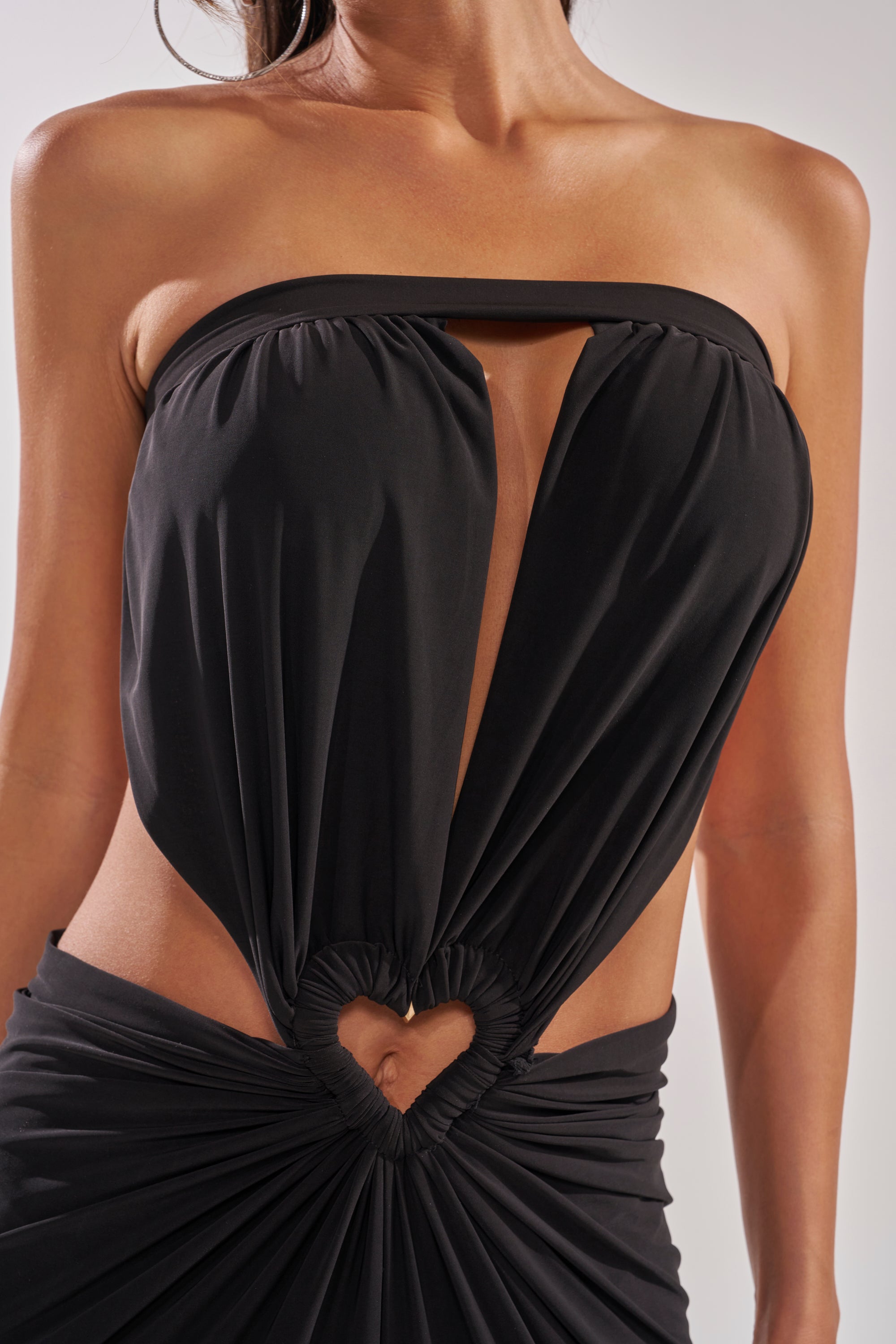A woman wears the DONT BREAK MY HEART STRAPLESS MAXI DRESS, a formal black maxi with a strapless design, plunging neckline, heart-shaped midriff cut-out, and elegant waist gathering. 7