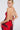 Woman with slicked-back blonde hair wearing large hoop earrings and the ROSEY MIDI DRESS—a bold rose-patterned, curve-hugging, backless dress with thin crisscross straps—poses with her back turned, glancing over her shoulder.