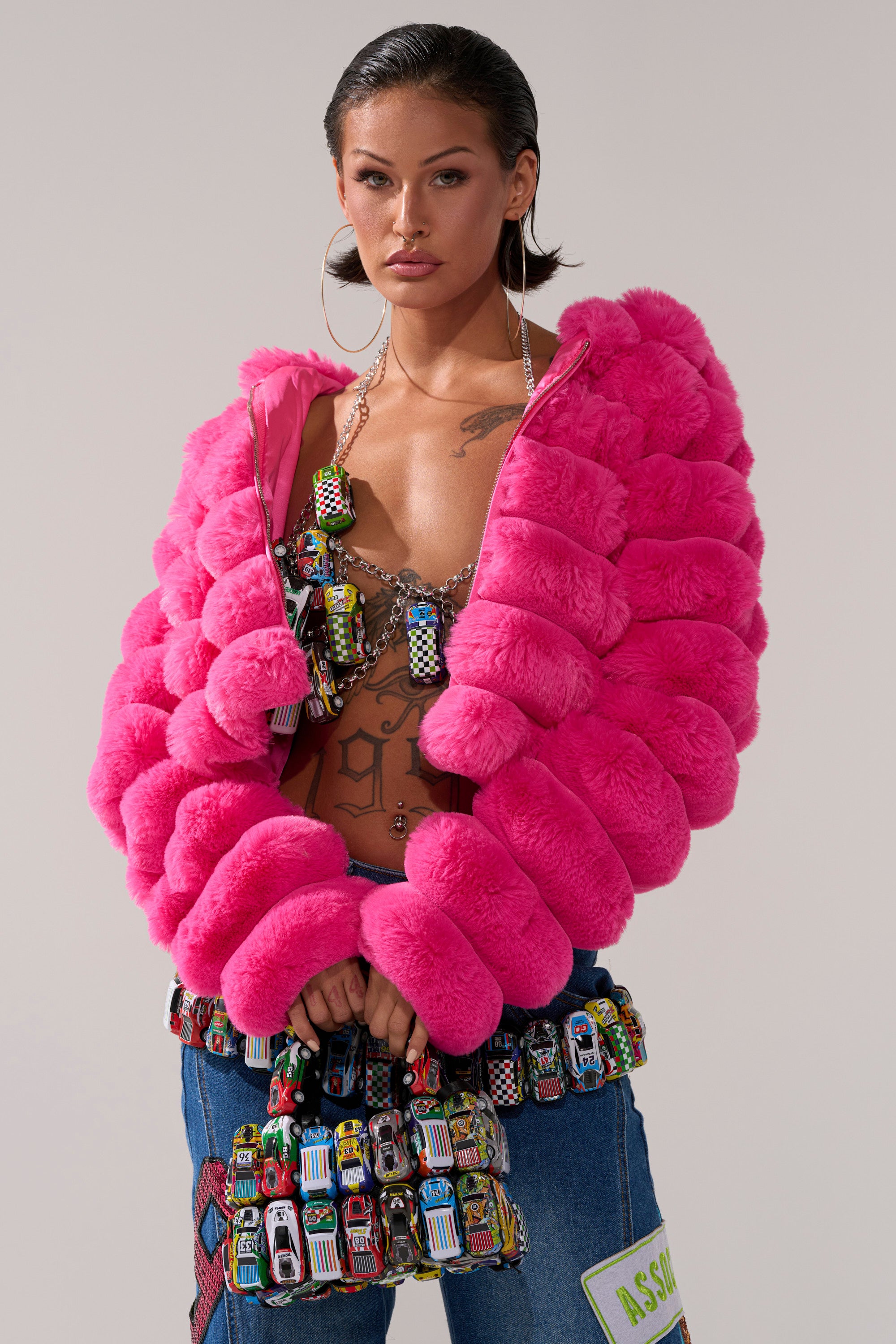 A woman wearing the POPCORN FAUX FUR IN PINK jacket, perfect for stylish winter outerwear.