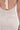 A close-up shows the back of a person wearing the ALWAYS BEST DRESSED MIDI DRESS IN IVORY, featuring an open-back halter neck tie and visible scrunched textured details on its off-white fabric.