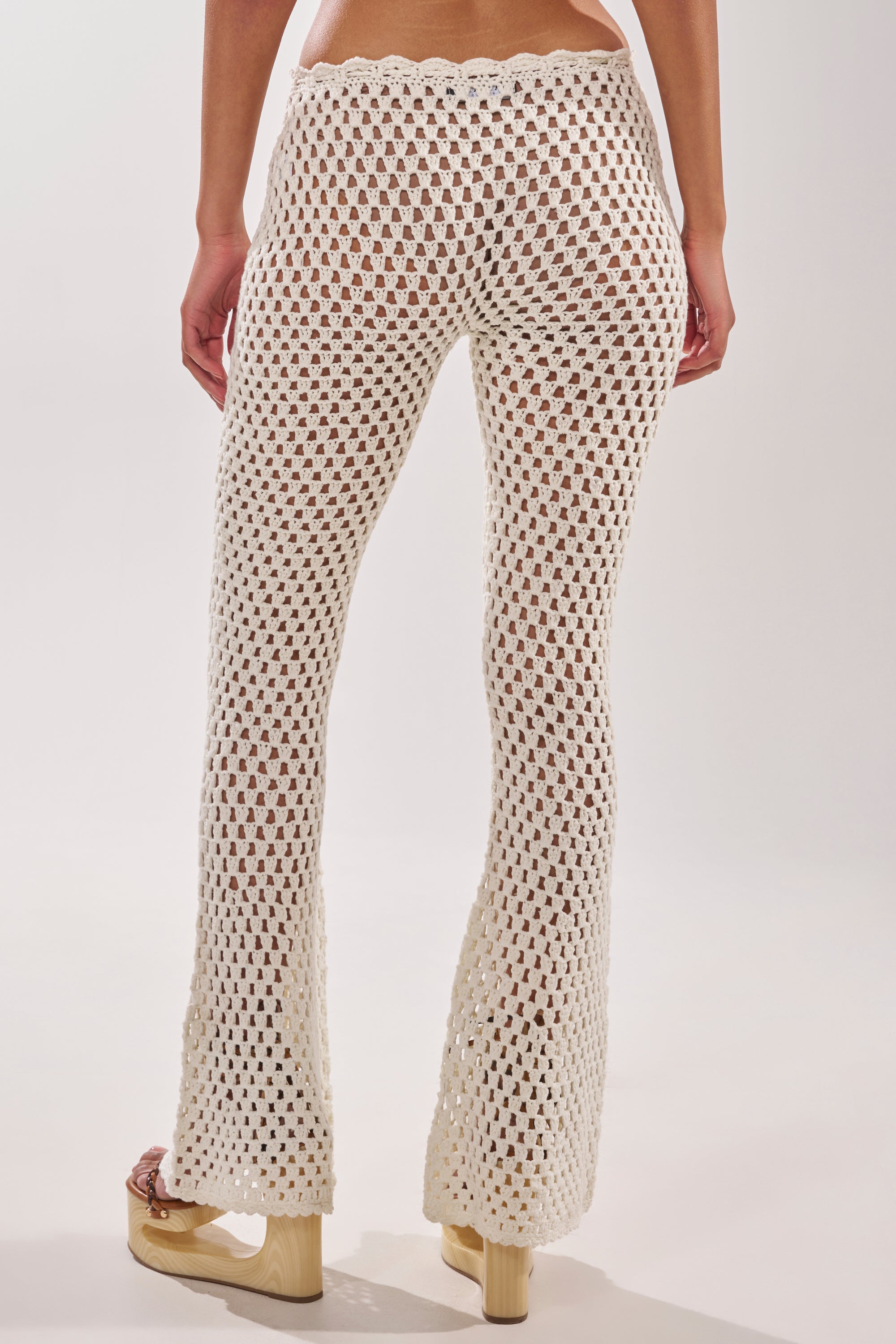 A person wearing the BEACH VIBES CROCHET FLARED PANT, a stylish choice perfect for resort wear. 4