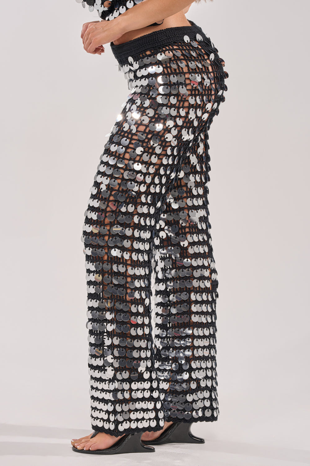 Someone is wearing the GIVE IT TO ME BABY CROCHET PANT with open-toe black heeled shoes, set against a plain light-colored background. 2