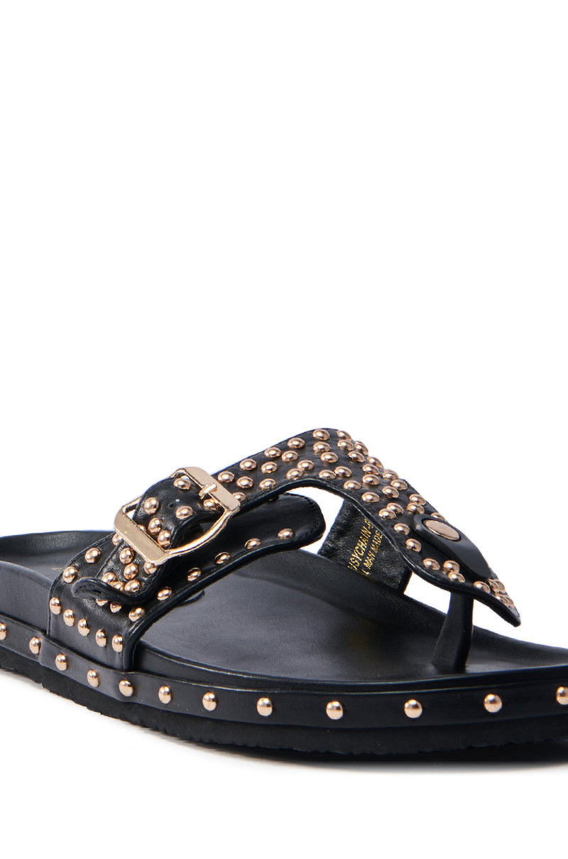 The AZALEA WANG DAISY CHAIN STUDDED BLACK SANDAL features faux leather in black with metallic gold studs, a strap buckle, thong style design, flat sole, and decorative edge studs for a chic appearance.