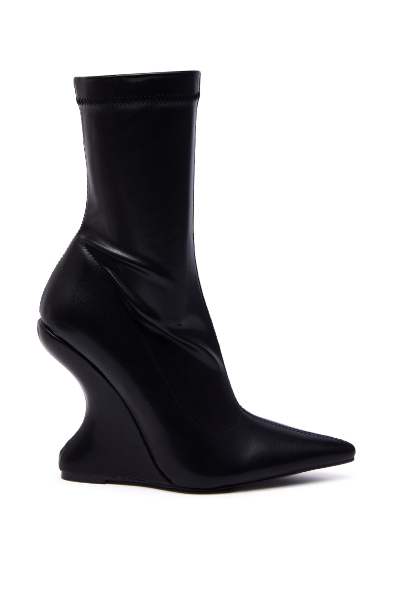 The AZALEA WANG DAMAN BLACK PU WEDGE BOOTIE features a pointed toe, sculptural curvy wedge heel, and shiny black PU material—delivering bold, modern style to elevate any look.