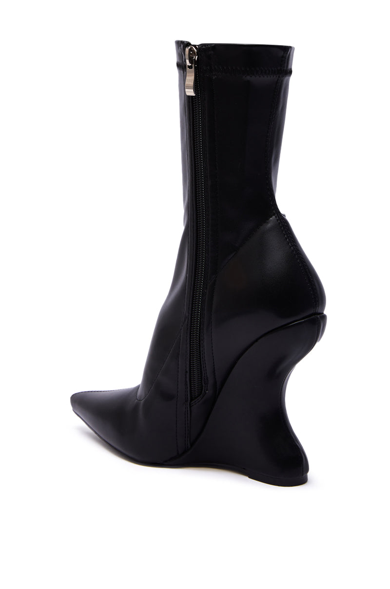The AZALEA WANG DAMAN BLACK PU WEDGE BOOTIE features a sharply pointed toe, side zipper, and an eye-catching sculpted curved heel for a standout look.