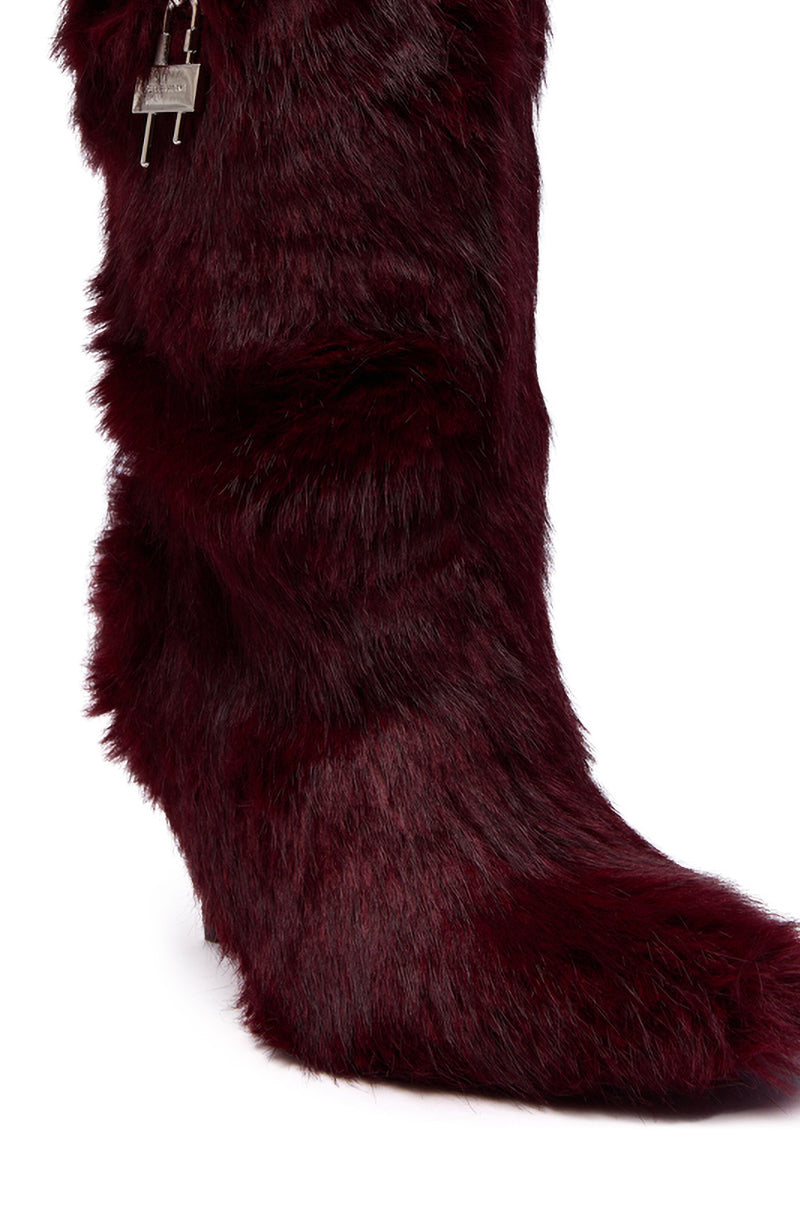 The AZALEA WANG DAMME RED FUR BOOTIE WITH LOCK DETAIL is a high-heeled mid-calf bootie in dark burgundy faux fur, featuring a visible zipper pull and lock detail near the top.