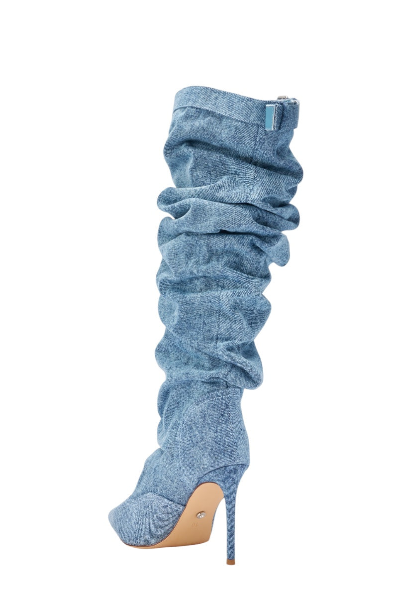 The AZALEA WANG DARIA DENIM STILETTO BOOT is a light blue, slouchy knee-high denim boot with a pointed toe and high stiletto heel, shown in profile on a white background. 5