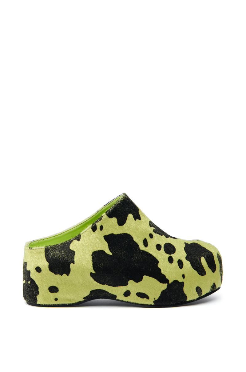 Side view of the AZALEA WANG DARWIN LIME FLATFORM clog showcasing its contemporary slip-on style with a striking lime green and black cow print pattern on the synthetic pony hair upper material. The inside lining is also lime green, and the black flatform sole provides added height. This design features a closed toe and an open back.