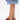 A person in a knee-length denim skirt and AZALEA WANG DARWIN CLOG IN BROWN SNAKE with chunky heels stands against a plain white background.