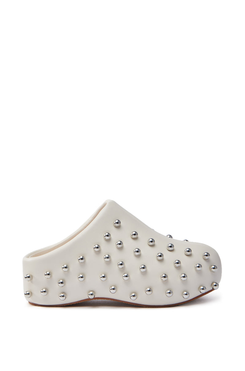 The AZALEA WANG DARWIN STUD FLAT CLOG IN BONE is a closed-toe white clog made from faux leather with a smooth finish. It features a thick flatform sole and is embellished with small silver metallic studs in a textured pattern.