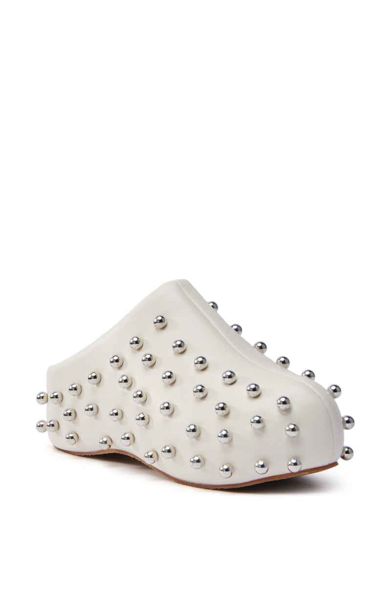 The AZALEA WANG DARWIN STUD FLAT CLOG IN BONE is a white slip-on crafted from faux leather, featuring silver metallic studs for a modern, textured look. Its unique curved design and flatform sole embody contemporary, avant-garde style.