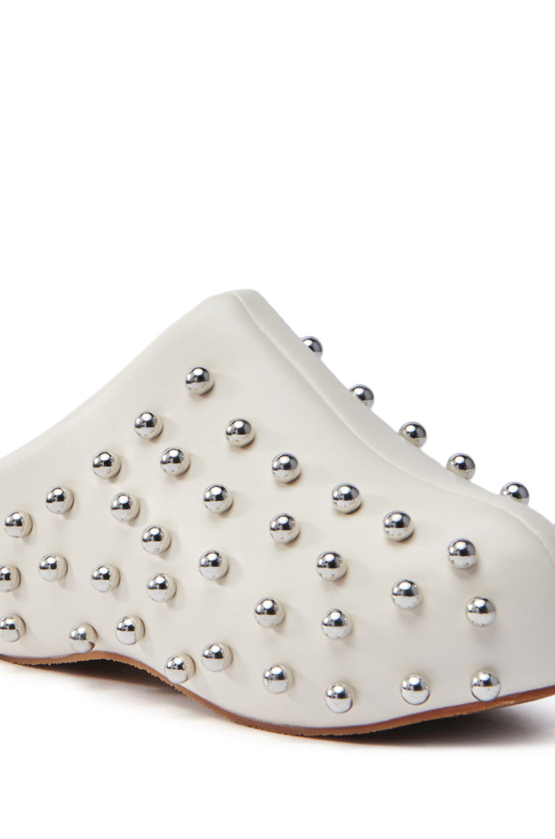The AZALEA WANG DARWIN STUD FLAT CLOG in bone features a close-up design of white faux leather adorned with numerous silver metallic studs for a textured look. The evenly distributed studs add to its modern, edgy aesthetic, perfectly enhanced by a trendy flatform sole.