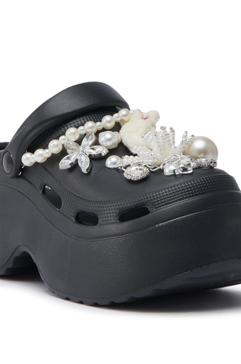 A close-up of the AZALEA WANG DAVIES BLACK PEARL RHINESTONE FLAT, featuring pearl-like beads, silver floral charms, and a small white bear charm on the upper part.