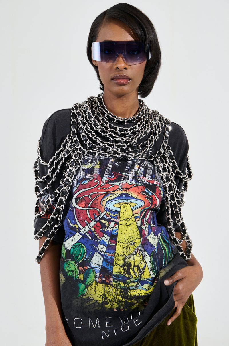 A person wearing a graphic t-shirt with a UFO design, large sunglasses, and the KYKY STATEMENT NECKLACE elegantly draped over their shoulders stands confidently with one hand on their hip against a plain background. 1