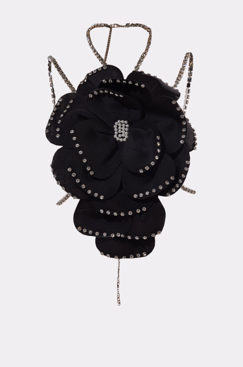 The LET ME BLOOM BODY CHAIN features a black oversized fabric flower with rhinestone-outlined petals at the center and thin, sparkling rhinestone straps, creating a striking and ornate accessory. 6