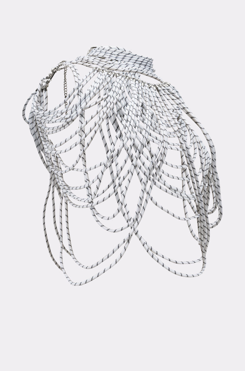 The COURTSIDE BODY NECKLACE features multiple white cords with black stripes, draped and layered to form an intricate, sculptural web that elegantly covers the shoulders and upper torso. 5