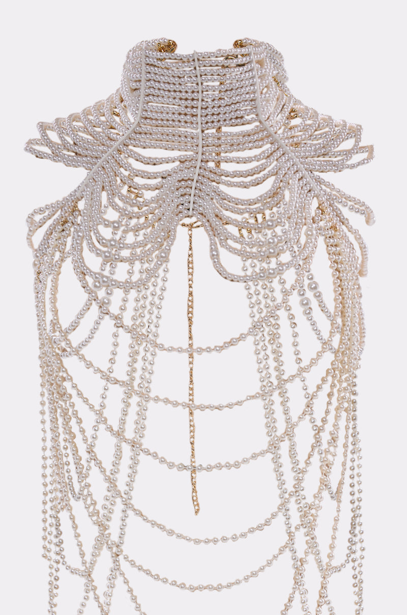 The FEELIN DEMURE BODY CHAIN features a high-collar layered choker design with cascading faux pearls and gold chain accents, creating an intricate statement piece that drapes elegantly downward. 5
