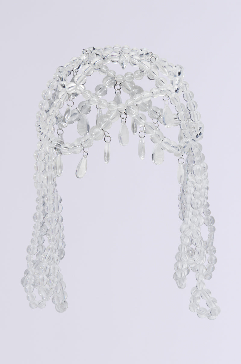 The CLEAR TO YOU DRIPPY HEAD PIECE features an ornate design with translucent bead embellishments and dangling teardrop beads, cascading elegantly against a plain gray background. 3