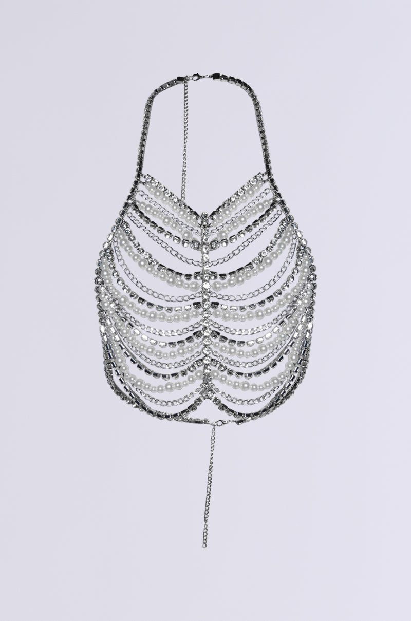 The EVA PEARL AND RHINESTONE BODY CHAIN is a silver chain halter-style top with round crystal accents, cascading rows, and a thin chain hanging from the center of the bottom edge, set against a plain gray background.