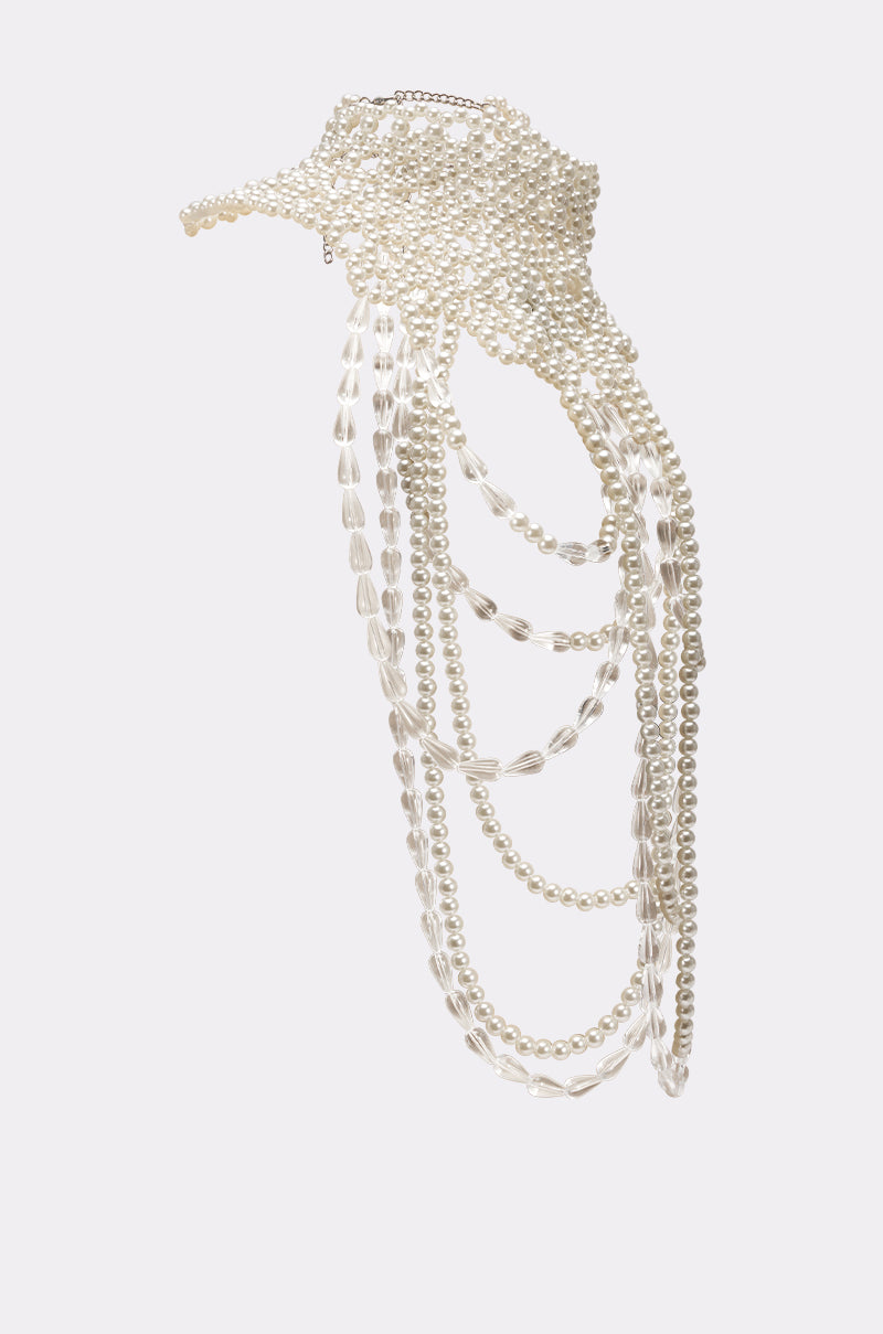 The ELEGANCE IS ME STATEMENT NECKLACE showcases layered white pearl strands in an intricate, asymmetrical design, offering a sophisticated accessory against a light gray background. 5