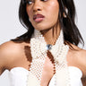 A woman wearing a white strapless top and the BUTTONED UP PEARL COLLAR, featuring a vintage-inspired design with a large statement gem, looks to the side. Her makeup is polished with glossy lips and soft hair.