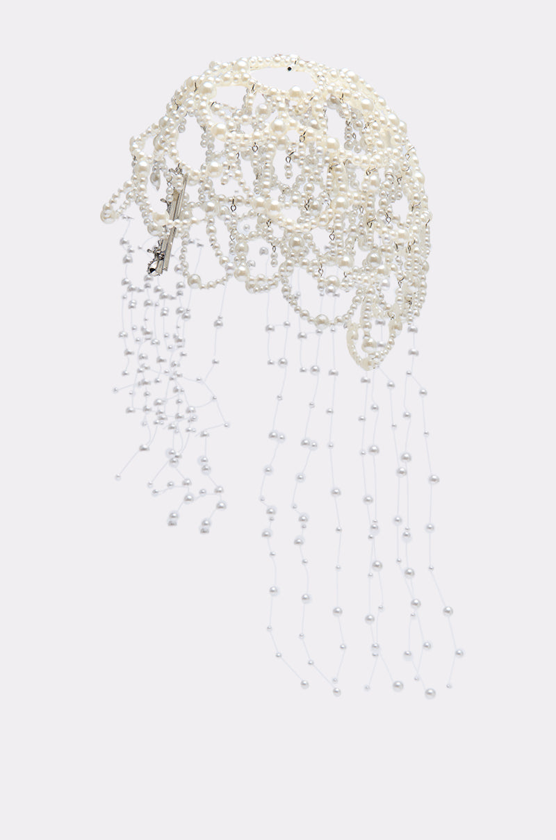 The PEARL LOVE HEADPIECE features interconnected pearls and beads in a sculptural, web-like design, with strands that cascade to form a delicate pearl veil effect against a plain background.