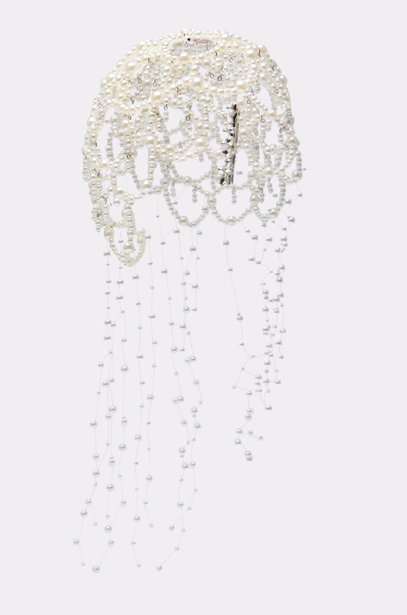 The PEARL LOVE HEADPIECE features a delicate, jellyfish-inspired design with white pearls and beads forming a rounded top and long, trailing strands, beautifully set against a plain light background.