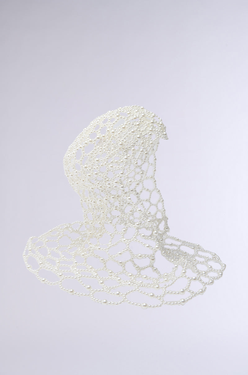 The ELEGANT VIBES PEARL HEADPIECE features a white mesh-like design of interconnected beads, creating an abstract, flowing shape that evokes modern elegance against a light gray background.
