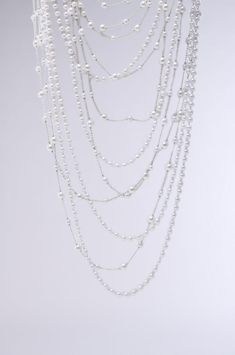 The IM TOO PRETTY NECKLACE features several delicate silver chains with small faux pearls, elegantly draped in a cascading choker silhouette against a plain light gray background. 2