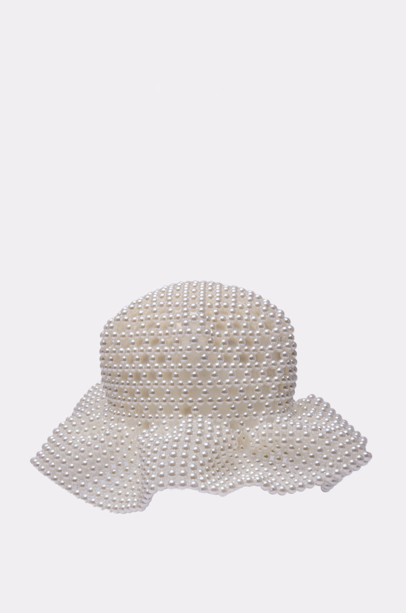 The PEARL DREAMS BUCKET HAT features a wide brim and is adorned with evenly spaced white pearls, creating a luxurious look. Displayed on a plain white background, this accessory is ideal for those who love pearls. 2