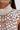 A close-up of a woman in the CLEOPATRA RHINESTONE CHAIN TOP, layered faux pearl necklace, silver star earrings, and a metallic netted top with large crystals and pearl drops; only her lower face, neck, and chest are visible.
