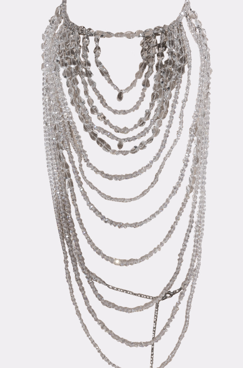 The CLEAR TO ME BODY CHAIN is a statement piece with multiple cascading strands of clear, faceted beads and crystals arranged in elegant, sparkling layered rows.