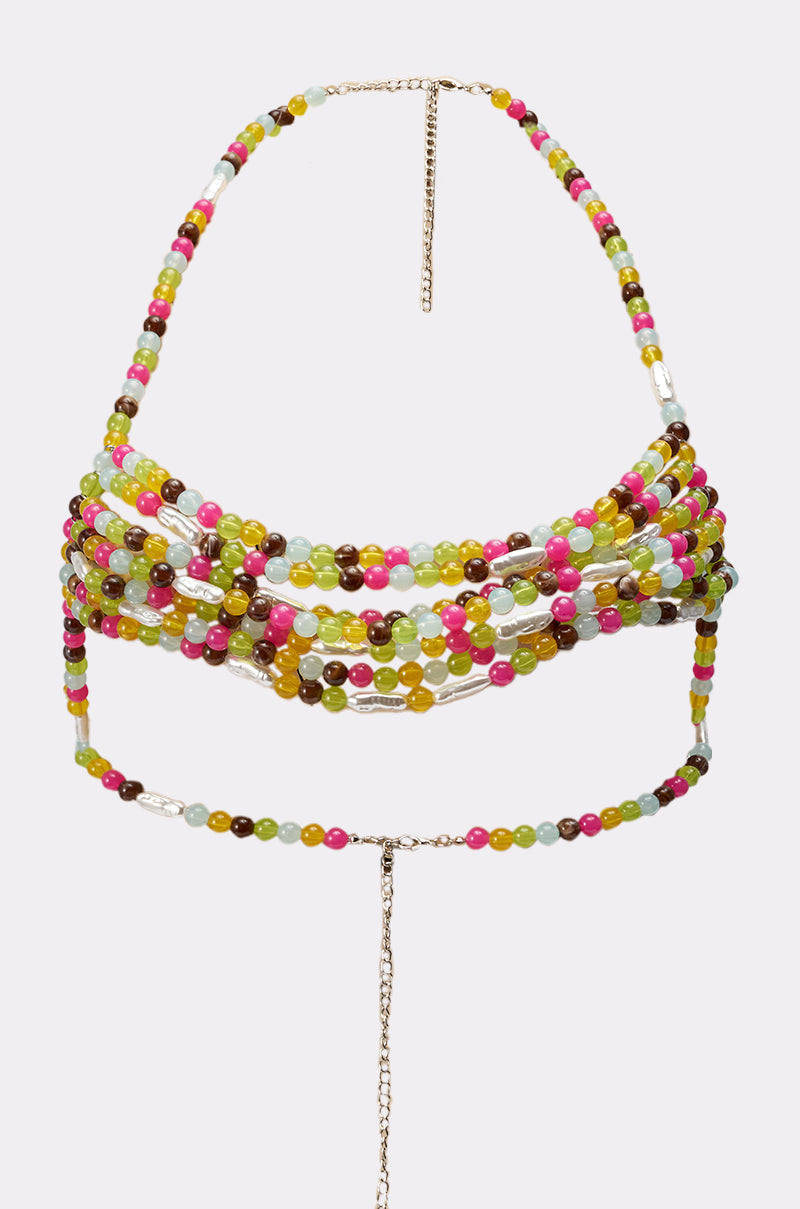 The IN YOUR DREAMS BODY CHAIN is a vibrant multicolor beaded accessory with pink, green, yellow, brown, and blue beads plus gold accents—perfect for festivals and can be worn around the neck and torso. 3
