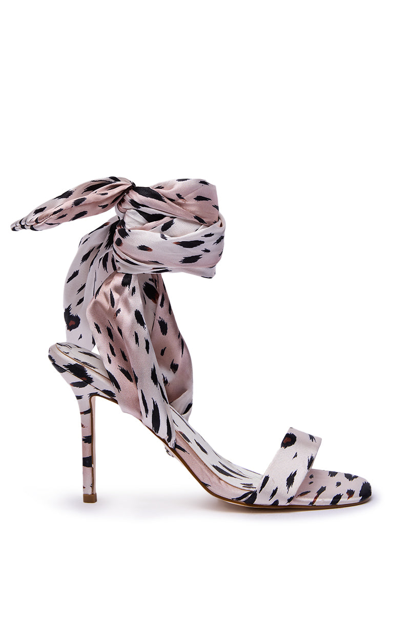 The AZALEA WANG DEEPA CHEETAH SATIN WRAP UP SANDAL features a thin stiletto heel, open toe, and wide ankle tie strap, with pink and black abstract cheetah spots for standout style.