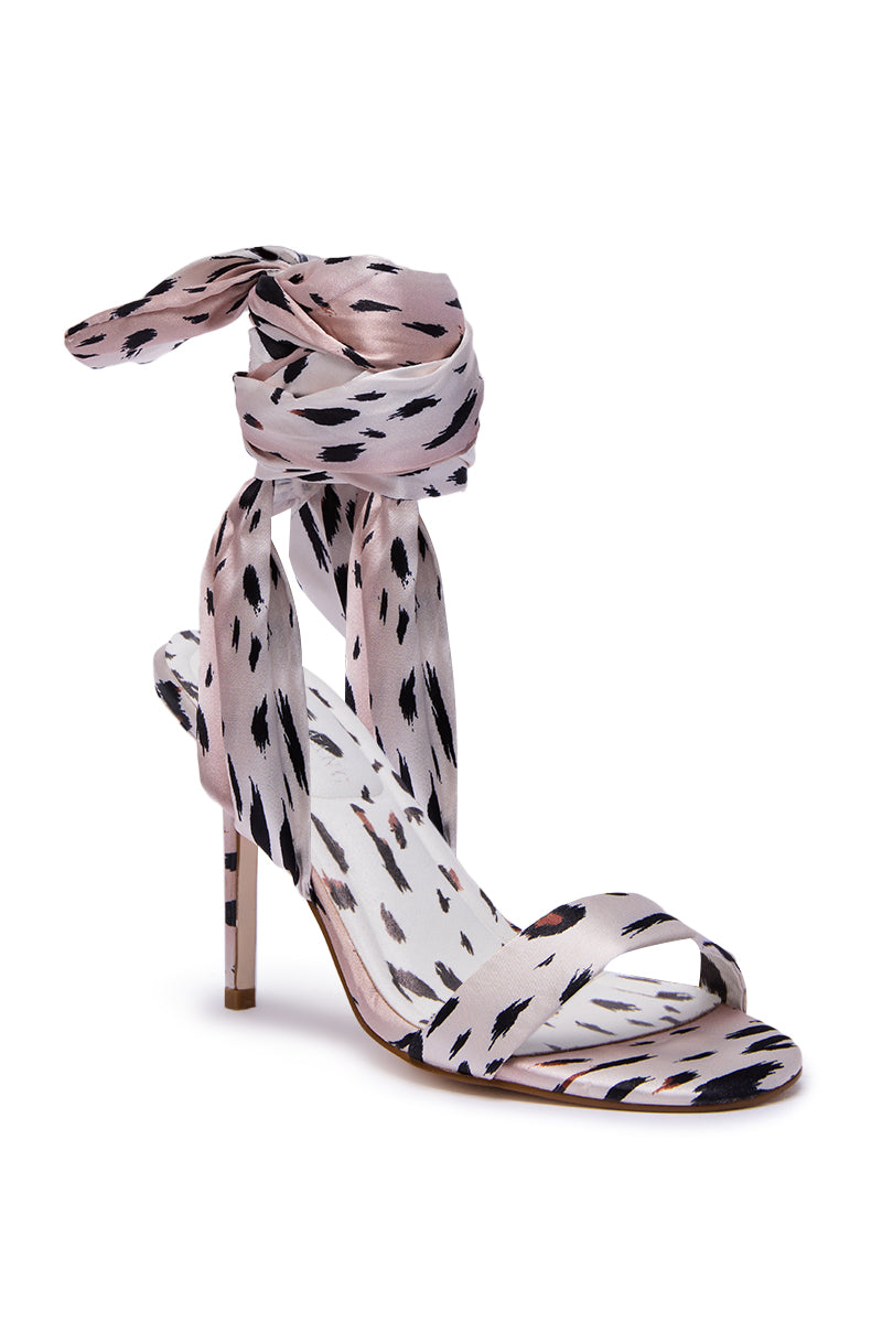 The AZALEA WANG DEEPA CHEETAH SATIN WRAP UP SANDAL features a pink base, black-and-white cheetah print, stiletto heel, thin toe strap, and long matching fabric straps that wrap elegantly around the ankle.