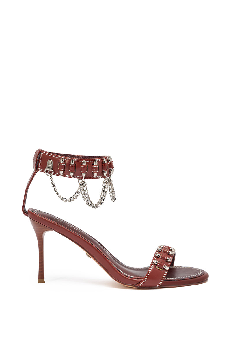 The AKIRA GOLD DELCROIX BROWN STILETTO SANDAL features faux leather, a single front strap, and an ankle strap with silver chain and stud details for a stylish, edgy look. 3