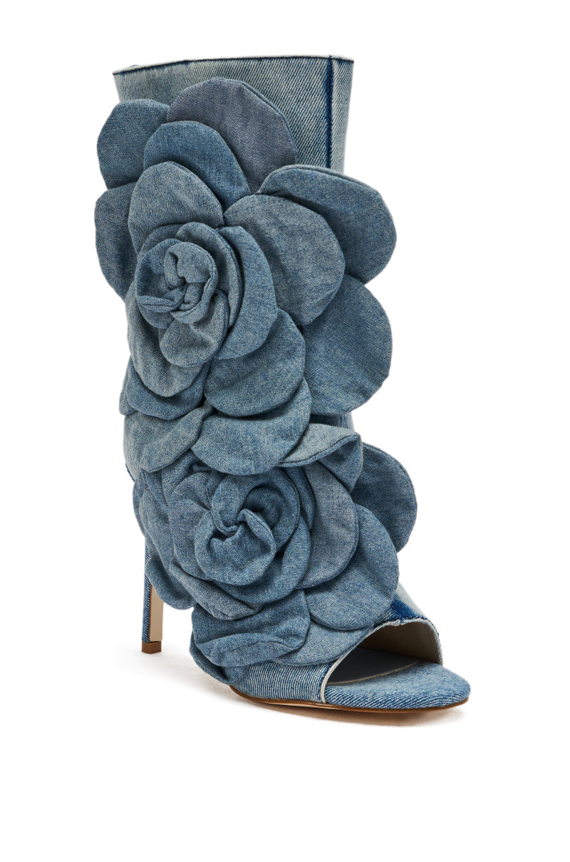 The AZALEA WANG DELMARE DENIM FLORAL OPEN TOE BOOTIE is a high-heeled stiletto bootie in denim, featuring an open toe and bold layered floral appliques on the front and side.
