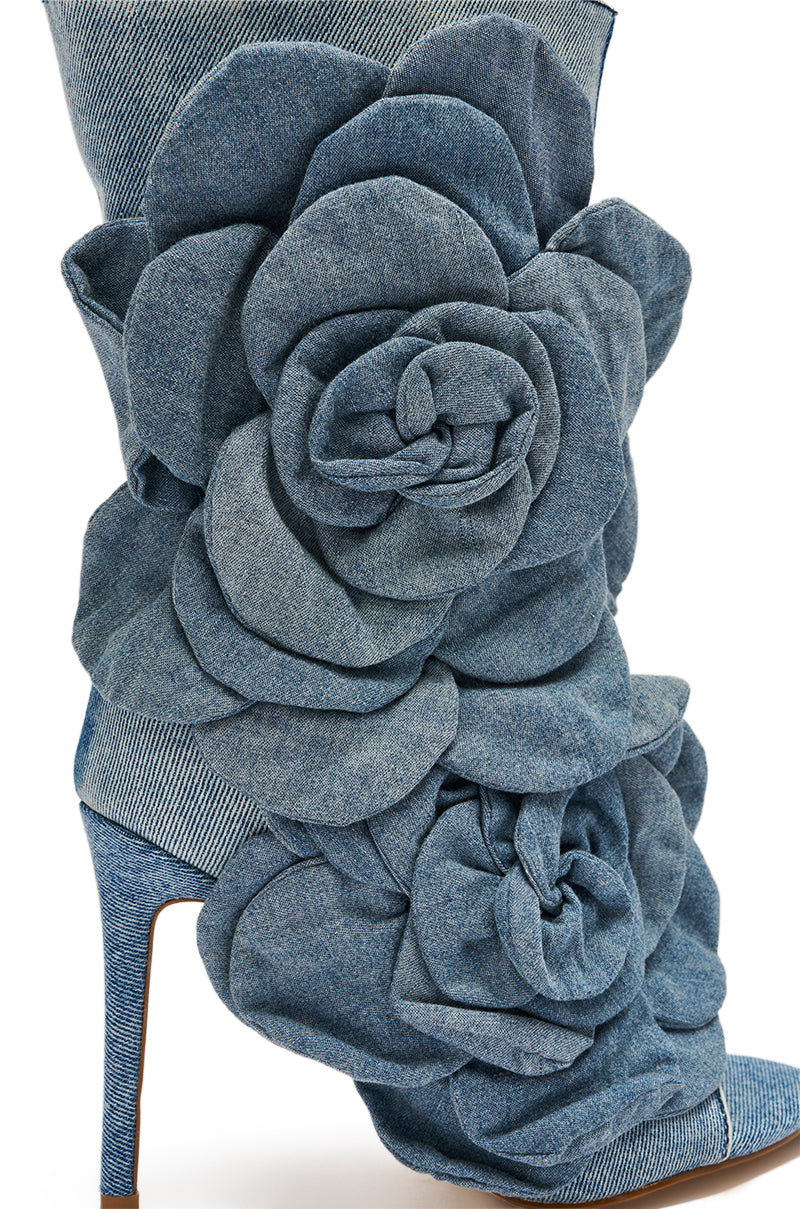 The AZALEA WANG DELMARE DENIM FLORAL OPEN TOE BOOTIE showcases a sleek stiletto heel and bold sculpted floral appliques as eye-catching accents along the side.