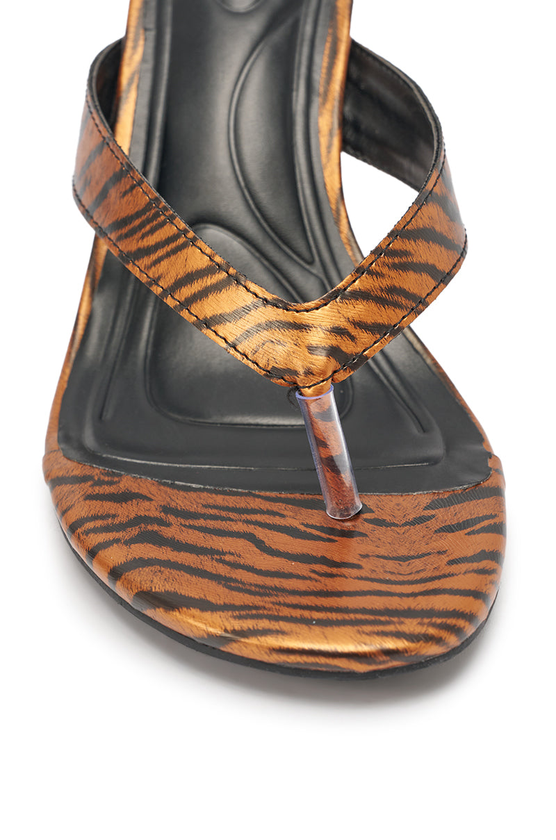 The AKIRA GOLD DELYSE ORANGE TIGER PRINT PU SLIP ON STILETTO SANDAL features an orange and black tiger print, a black cushioned footbed, and a clear thong strap, shown close-up on a white background. 7