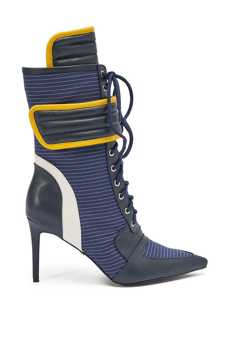 The AKIRA GOLD DEMAND NAVY STILETTO BOOTIE features a high heel, pointed toe, blue pinstriped fabric, navy faux leather accents, white side panel, yellow trim, lace-up front, and padded collar. 2