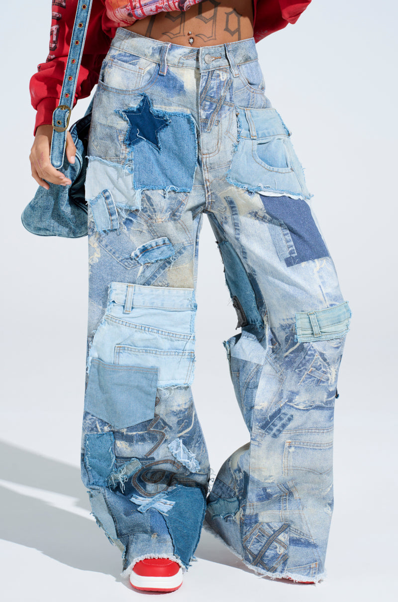 Wearing DENIM ON DENIM PATCHWORK JEANS in various blue shades and star designs with distressed detailing, the person completes the chic look with a denim bag and red-and-white sneakers.