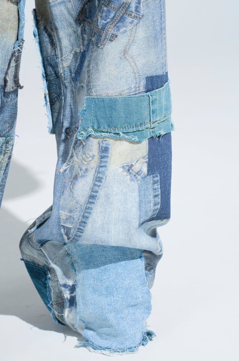 Close-up of DENIM ON DENIM PATCHWORK JEANS, featuring a high-rise wide leg with varied blue shades. Visible stitching and frayed edges enhance the distressed detailing and intricate textures of the denim patches.