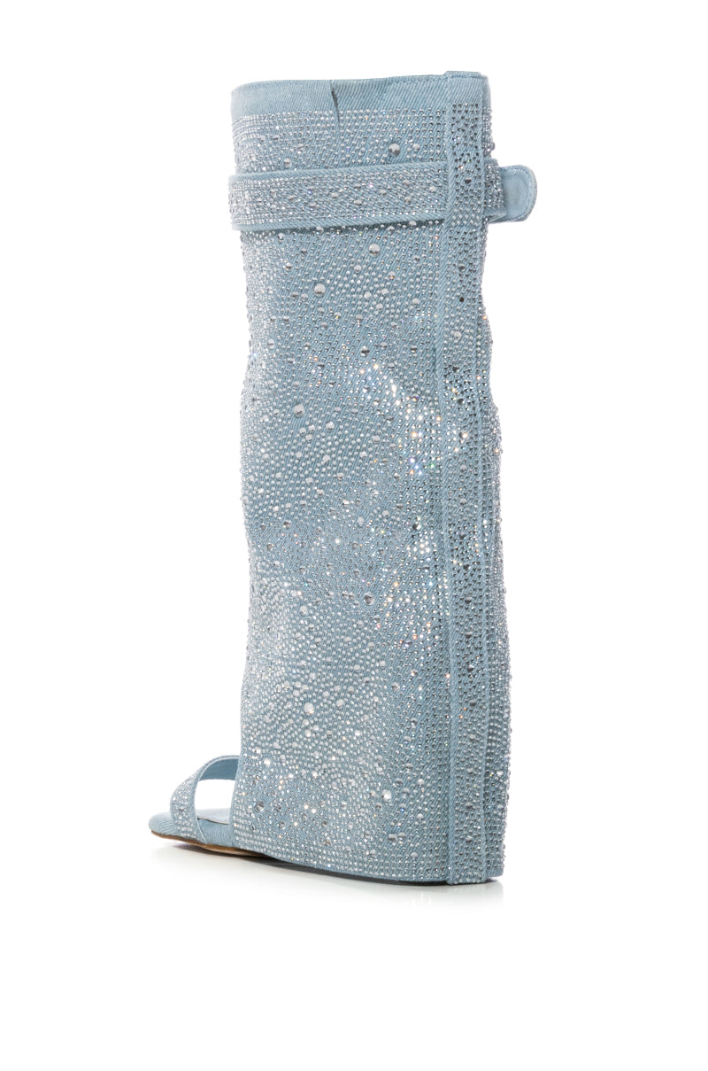 The AZALEA WANG DESARAY RHINESTONE OPEN TOE WEDGE BOOTIE, a single light blue knee-high boot with a flat sole and side zipper, dazzles with its rhinestone embellishments against a plain white background.