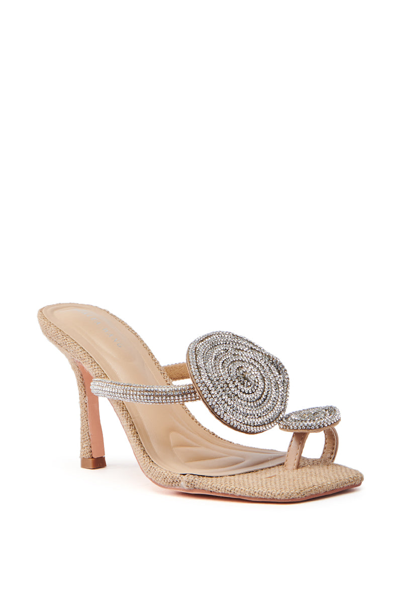 The AZALEA WANG DIARA Beige Raffia Embellished Stiletto Sandal features a thin strap, toe loop, and a rhinestone-adorned circular silver piece. It has an open square toe and a textured surface for added flair.