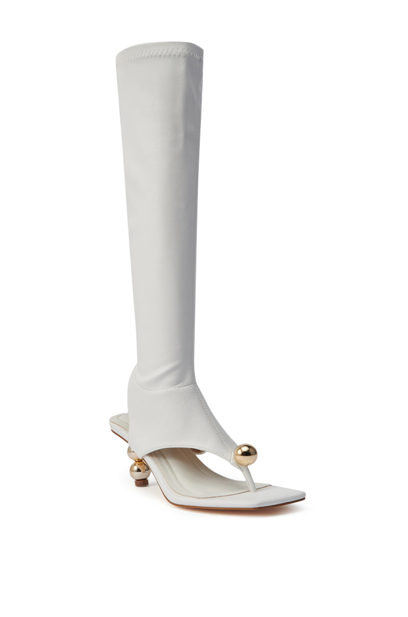 The AZALEA WANG DIPPIN DOT WHITE STRETCH SANDAL BOOT features faux leather, gold orb heels, a flat sole, open-toe, and a square toe with gold sphere accents in a unique knee-high design.