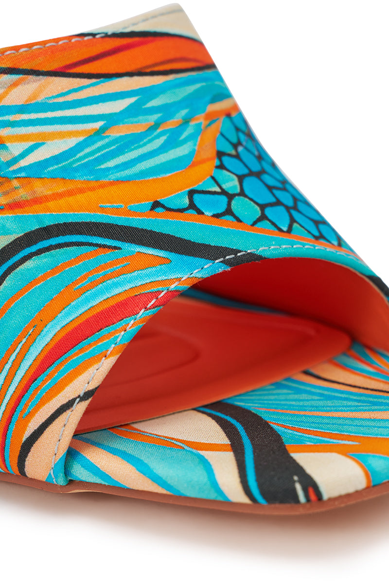 A close-up of the AKIRA DOMNINA BLUE MULTI STILETTO PRINT SANDAL displays its colorful abstract blue, orange, teal, and beige pattern and an orange comfort-cushion insole. 6