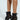 Someone wearing AZALEA WANG DOROTHY black stiletto booties with silver button details and thin high heels, featuring a sheer leopard print pattern crafted from mesh textile, set against a plain white background.
