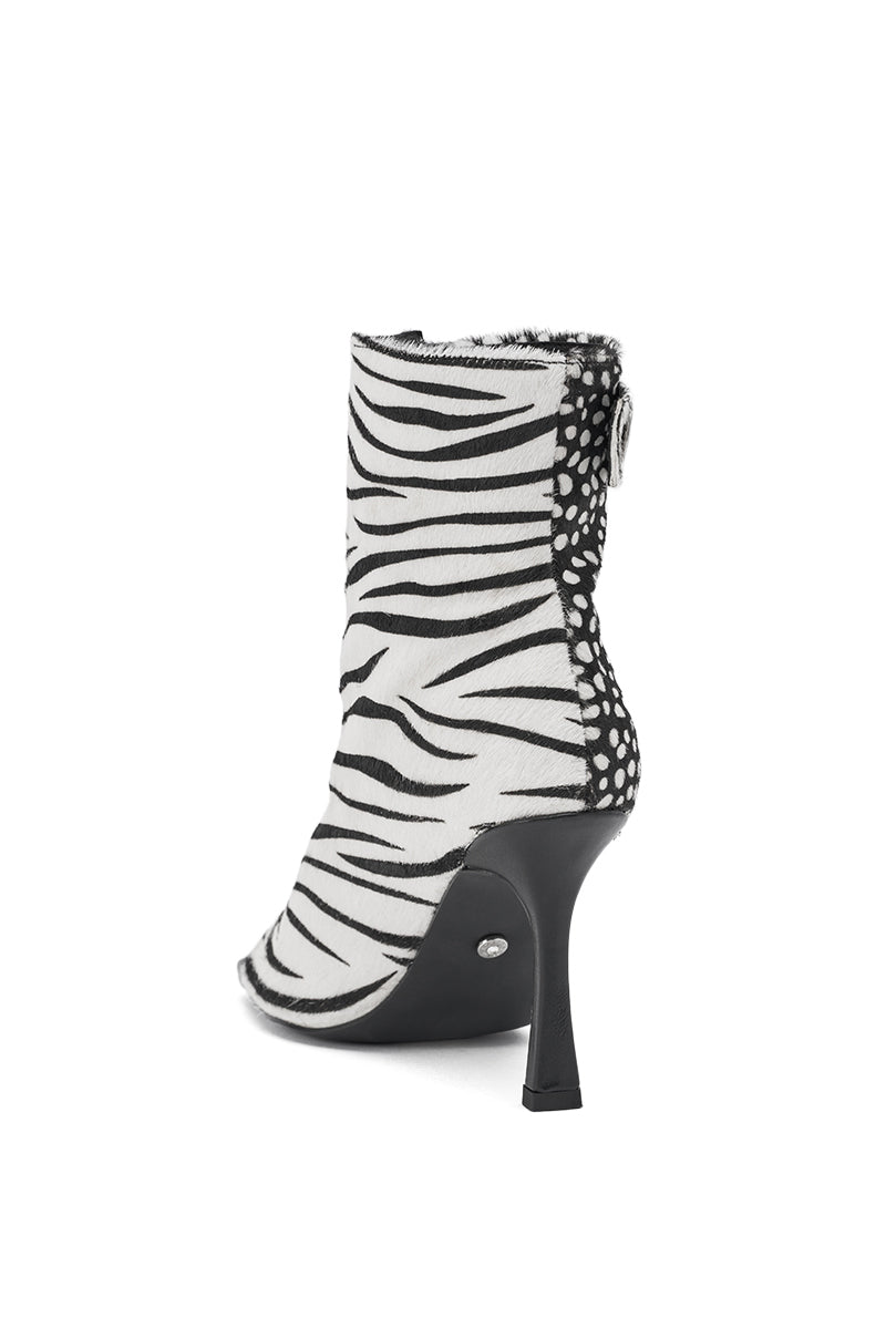 The AZALEA WANG DOROTHY BLACK CHEETAH CALF HAIR PRINTED STILETTO BOOTIE features a high heel, animal print design with black and white patterns, a pointed toe, and spot-detailed back panel. Photographed on a clean white background.
