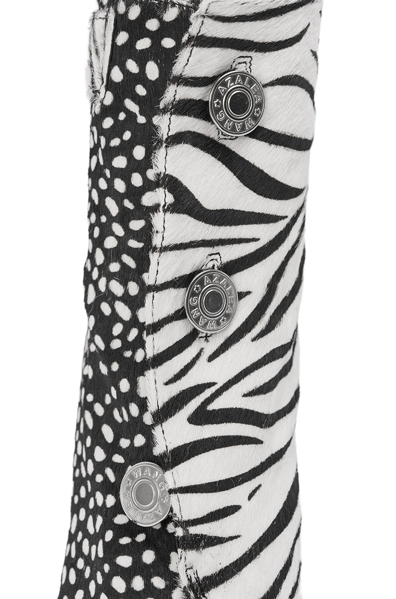 Close-up of fabric with black and white zebra stripes and polka dots, plus three metallic "RAG & BONE JEANS" buttons—an eye-catching design that pairs perfectly with the AZALEA WANG DOROTHY BLACK CHEETAH CALF HAIR PRINTED STILETTO BOOTIE.