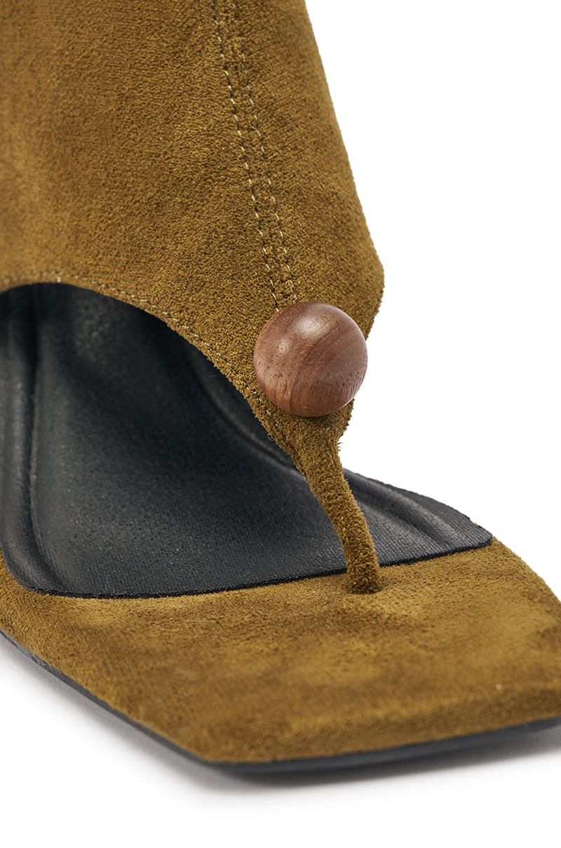 Close-up of a brown suede sandal with square toe, black footbed, and a sculptural wooden beaded strap detail, inspired by the artistry of our AZALEA WANG DOTTIE OLIVE STRETCH FAUX SUEDE BOOT with embellished heel and toe hardware. 5